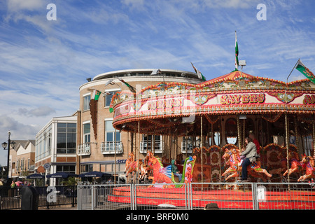 Cardiff Bay (Bae Caerdydd), Glamorgan, South Wales, UK, Europe. People on horses on fairground carousel ride on the waterfront Stock Photo