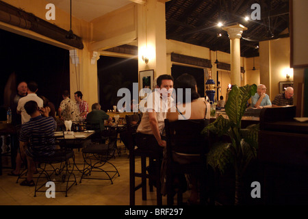 People are gathered inside The Foreign Correspondents Club (FCC) to enjoy food and drink in Phnom Penh, Cambodia. Stock Photo