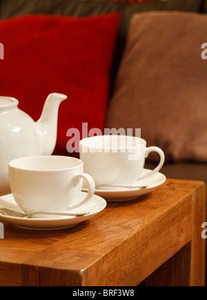 Teapot and cups on a table in a cozy den Stock Photo