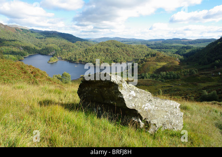 View of boulder in The Pass of the Cattle and Loch Katrine The Trossachs Stirlingshire Scotland Uk Stock Photo