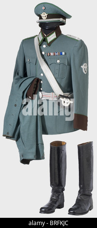 A uniform ensemble for a First Lieutenant of Municipal Police.,A visor cap of blue-green gabardine with brown cap band and light-green piping,a two piece,very fine,silver-plated eagle,silver cap cord,brown linen/oil cloth lining,ersatz material sweatband. Visor loose. Size 57. Tunic of blue-green gabardine with brown collar and lapels,light green lace,silver-embroidered collar patches and sleeve eagle,green silk lining,pinned on ribbon bar. Riding breeches of matching material. Blue-green wool overcoat with a brown collar and light green lace,green ,Additional-Rights-Clearences-Not Available Stock Photo