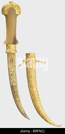 A golden Moroccan presentation koummya,circa 1900.Typically curved blade with a double-edged point,and entirely covered with gold-inlaid geometric ornamentation on both sides.Mountings and scabbard are of engraved massive gold.Rhinoceros horn grip with four small diamonds and a small red jewel set into the obverse side.Massive gold scabbard with two suspension rings.The obverse side is set with a large emerald(ca.10 x 10 mm).Length 27.5 cm.Total gold weight ca.150 g.Weight of the scabbard 127 g.historic,historical,1900s,20th century,19th centu,Additional-Rights-Clearences-Not Available Stock Photo