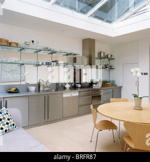 Glass shelving above stainless steel fitted units in modern kitchen ...