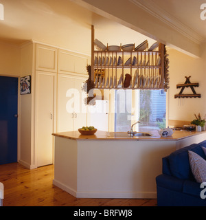 White plates on wooden plate rack above fitted unit with wood worktop in modern open-plan kitchen Stock Photo