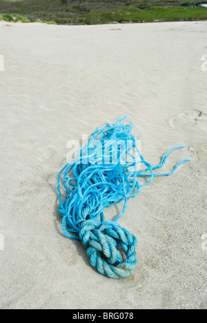 A discarded skein of blue rope on a sandy beach Stock Photo