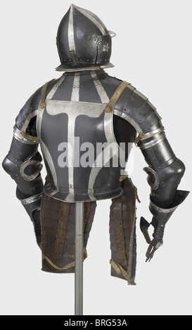 A black and white three-quarter armour,Nuremberg,circa 1540/50 Burgonet with a skull forged in one piece and rising to a point with four raised decorative strips.Brim and neck protector are worked en suite and have rolled,corded rims.A plume socket riveted at the nape of the neck.Hinged cheek flaps with six ear holes and embossed floral designs.Hinged gorget with pauldrons sliding on five lames.Two collar plates,the top one with a turned-under and corded flange.Heavy breastplate with laminated gussets and two taces.Attached tassets sliding on eight l,Additional-Rights-Clearences-Not Available Stock Photo