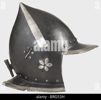 A black and white three-quarter armour,Nuremberg,circa 1540/50 Burgonet with a skull forged in one piece and rising to a point with four raised decorative strips.Brim and neck protector are worked en suite and have rolled,corded rims.A plume socket riveted at the nape of the neck.Hinged cheek flaps with six ear holes and embossed floral designs.Hinged gorget with pauldrons sliding on five lames.Two collar plates,the top one with a turned-under and corded flange.Heavy breastplate with laminated gussets and two taces.Attached tassets sliding on eight l,Additional-Rights-Clearences-Not Available Stock Photo