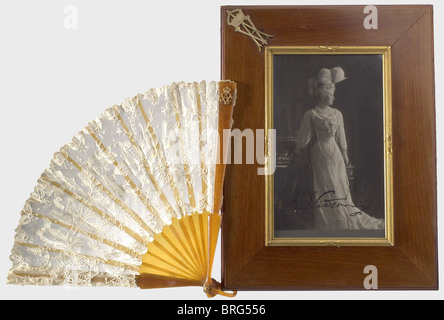 Empress Auguste Victoria (1858 - 1921), a fan in a case and a signed presentation photograph The fan is of imitation horn and Brussels lace bearing the gold cipher 'AV' under the empress' crown. In the original case bearing the empress' cipher. The silk lining on the lid bears the stamp of the court purveyor, 'Conrad Sauerwald' in Berlin, and there is a label for the 'Schatull- und Vermögensverwaltung Seiner Majestät des Kaisers und Königs Wilhelm II' (Office of the Privy Purse for His Majesty the Kaiser and King Wilhelm II). Tall format portrait photograph, ci, Stock Photo