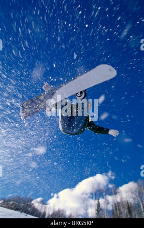 Male snowboarder flying through the air. Stock Photo