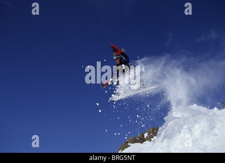 Male snowboarder flying through the air. Stock Photo