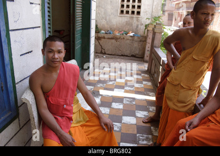 Buddhist monks enjoy a quiet morning on the porch of their living quarters at a temple in Phnom Penh, Cambodia. Stock Photo