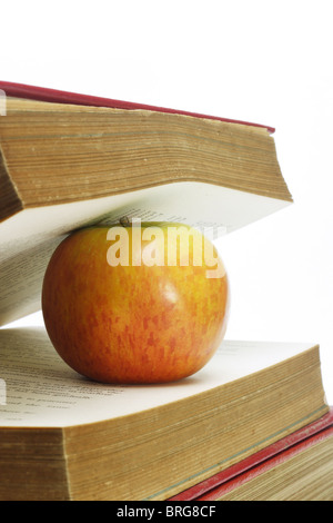 Close up of apple and old books on white background Stock Photo