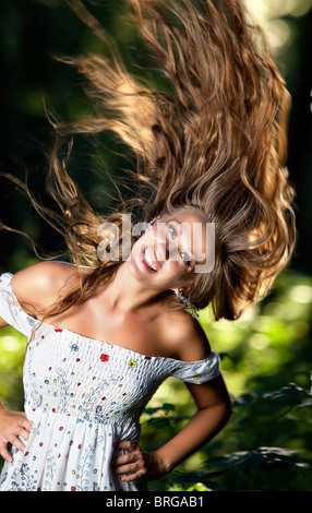 Young smiling woman with fluttering hair.