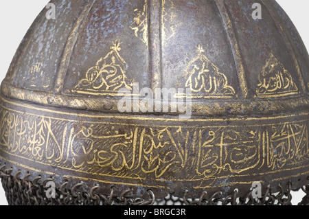 A gold-inlaid Persian helmet,17th/18th century Iron helmet,embossed from one piece,with a riveted conical top finial. The upper part of the skull is divided into segments by twelve riveted bars. Gold-inlaid script ornamentation(somewhat worn)all around it on the lower band and between the bars. Attached mail curtain of butted iron rings. Much of the helmet surface is corroded. The chain mail shows defects. The nose guard is missing. Total height 42 cm.,historic,historical,18th century,Persian Empire,object,objects,stills,clipping,clippings,cut ou,Additional-Rights-Clearences-Not Available Stock Photo