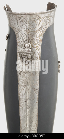 A pair of German greaves,ca. 1540/50 Closed greaves opening on hinges. Front and side etched with decorative strips of vines. Two original fastening hooks on the sides of each. Seven lame foot guard in the shape of a bear-paw sabaton with identical etched decoration. There is a knob for mounting a spur on each heel. Blacking renewed. Height 49 cm. Rare leg protection in good condition for a German three-quarter black and white armour.,historic,historical,16th century,defensive arms,weapons,arms,weapon,arm,fighting device,object,objects,stills,clip,Additional-Rights-Clearences-Not Available Stock Photo