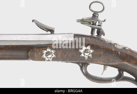A long miquelet flintlock shotgun,Giacomo Luciani in Rome,circa 1700.Two-stage barrel,octagonal then round with a slightly swamped muzzle.Smooth bore in 16 mm calibre.Silver front sight.Seven stars and two marks stamped on the chamber.Extremely high quality miquelet lock,finely engraved and cut with vine and grotesque ornamentation.Signed 'Giacomo Lociani' on the inside.Catalan half stock of beautifully figured thuja root wood.The forearm has a repaired break.Engraved silver furniture.The escutcheon bears a crowned coat of arms.Wooden ramrod with,Additional-Rights-Clearences-Not Available Stock Photo