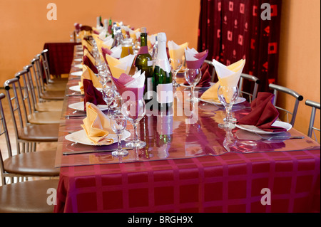 laid table with tableware and dishes for banquet in bordeaux and yellow tones, shallow DOF Stock Photo