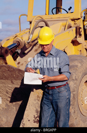 Supervisor checking maintenance log at a worksite, California, USA  1990s Stock Photo