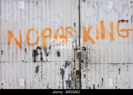 A hand-painted No Parking notice on a garage's gates under railway arches in south London. Stock Photo