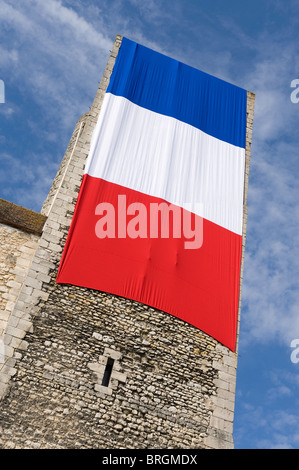 french flag draped over medieval castle tower, nemours, france Stock Photo