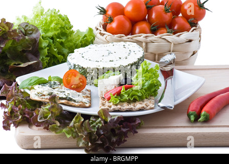 Healthily crackers with cheese, herbs, salad, tomato, olives and peppers Stock Photo