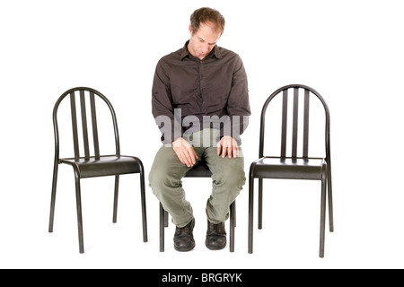 very sad man seated on chair alone Stock Photo