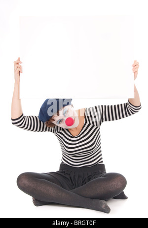 clown woman cross legged on floor holding blank billboard Stock Photo