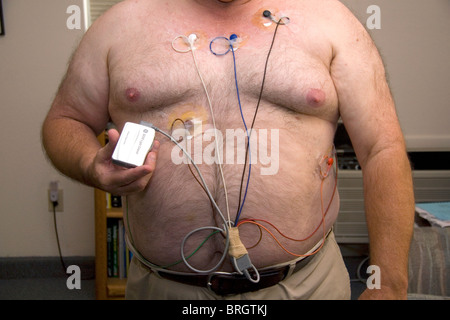 American man wearing a Holter monitor used for monitoring the heart for cardiac arrhythmias. MR Stock Photo