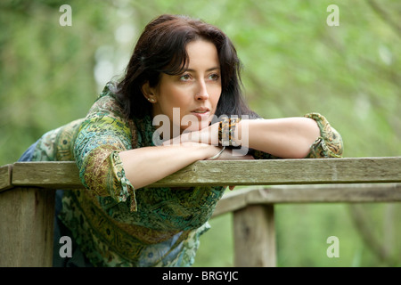 pensive woman relaxing in park at springtime Stock Photo