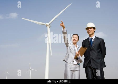 Businesspeople or engineers in front of wind turbines Stock Photo