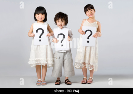 Children holding signs with question marks Stock Photo