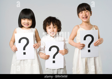 Children holding signs with question marks Stock Photo