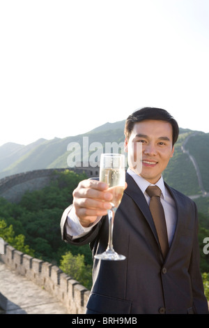 Businessman having champagne on the Great Wall Stock Photo