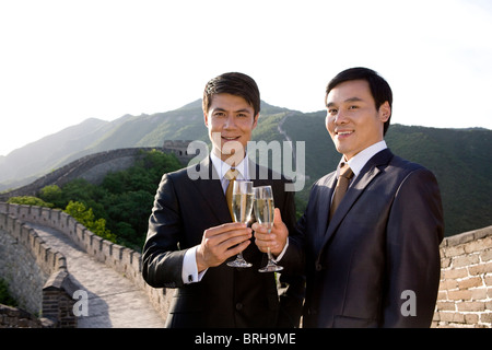 Businessmen having champagne on the Great Wall Stock Photo