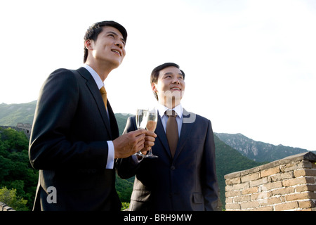 Businessmen having champagne on the Great Wall Stock Photo