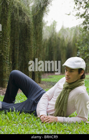 Portrait of Man Lying Down on Grass in Park Stock Photo