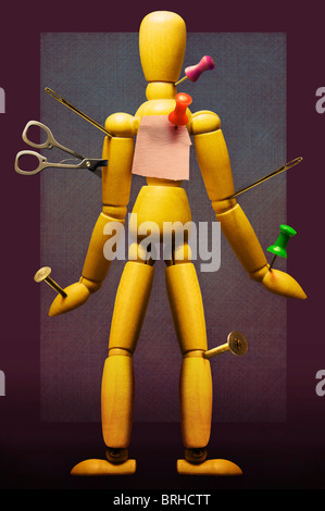 Sewing Needles, Scissors and Thumbtacks inserted into Artist's Mannequin Stock Photo