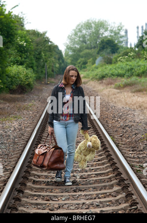 Teenage Girl Walking on Railway Tracks Stock Photo