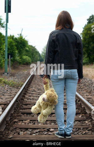 Teenage Girl Walking on Railway Tracks Stock Photo