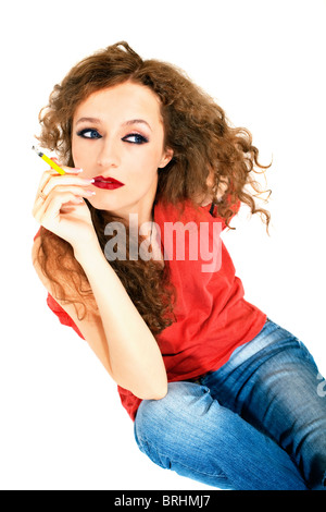 curly long-haired brunette woman with yellow cigarette on white background Stock Photo