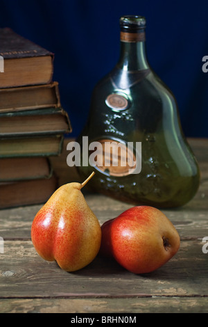Still life of two pears with bottle and books Stock Photo