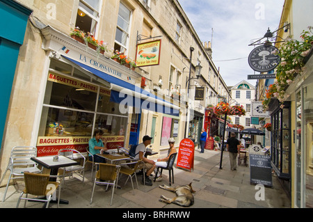 Horizontal wide angle of tourists walking and sitting along Northumberland Place in Bath city centre on a bright summer's day. Stock Photo