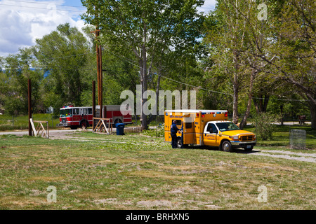 A rural fire departments paramedics treating a man injured by a falling tree Stock Photo