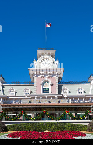 American flag flies over the railroad station near the entrance to the Magic Kingdom which is decorated for Christmas Stock Photo