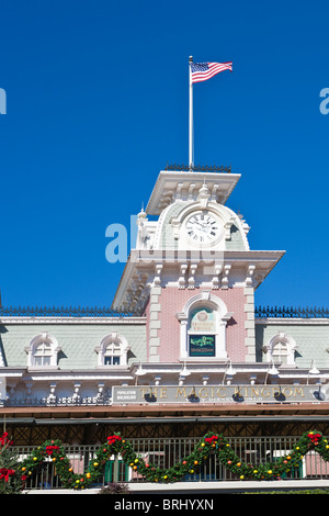 American flag flies over the railroad station near the entrance to the Magic Kingdom which is decorated for Christmas Stock Photo