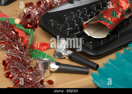 christmas party items next to an office computer keyboard Stock Photo