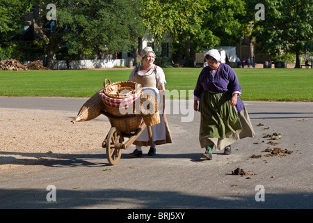 Woven basket makers in period clothing walk on street in Colonial Williamsburg, a living history museum in Williamsburg, VA Stock Photo