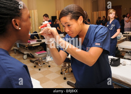 Nursing students conduct physical assessments on each other as part of their training. Stock Photo