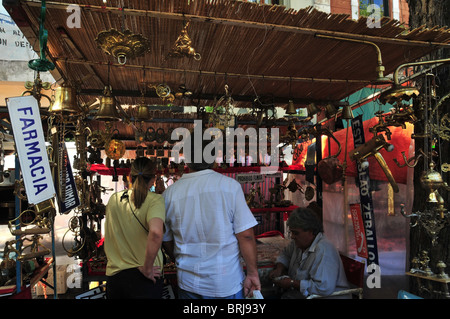 Back view of young man and woman looking at a market stall selling brass and copper ware, San Telmo Sunday Market, Buenos Aires Stock Photo