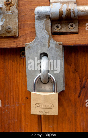 Padlock and bolt on a wooden door Stock Photo